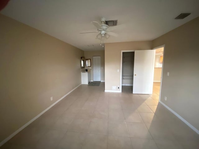 empty room featuring ceiling fan and light tile patterned floors