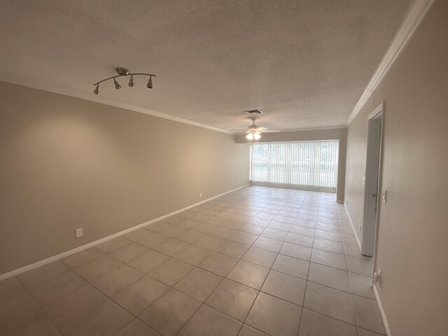 tiled spare room with ceiling fan and crown molding