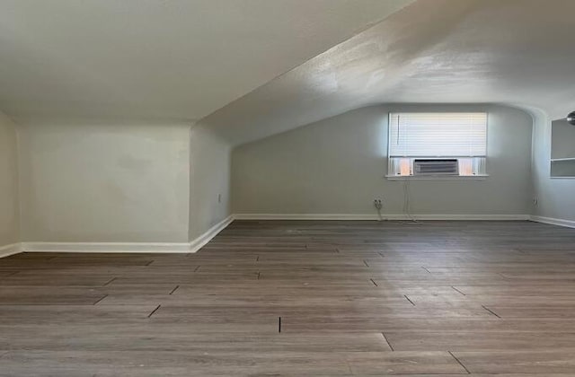 bonus room featuring hardwood / wood-style flooring, cooling unit, and vaulted ceiling