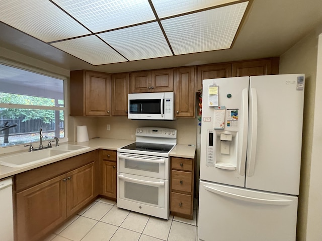 kitchen with sink, white appliances, and light tile patterned floors