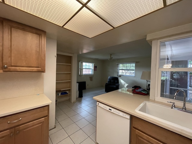 kitchen featuring white dishwasher, sink, light tile patterned floors, and ceiling fan