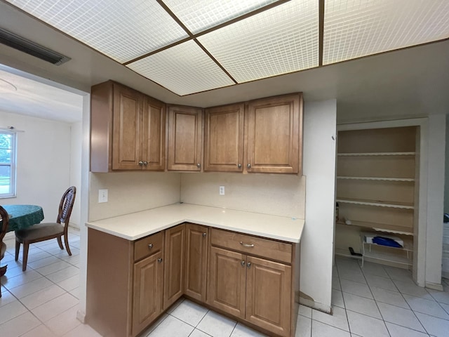 kitchen featuring light tile patterned flooring and backsplash