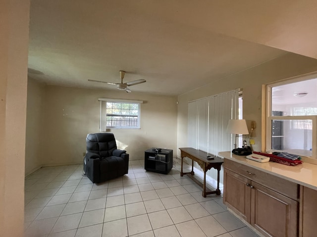 sitting room featuring light tile patterned flooring and ceiling fan