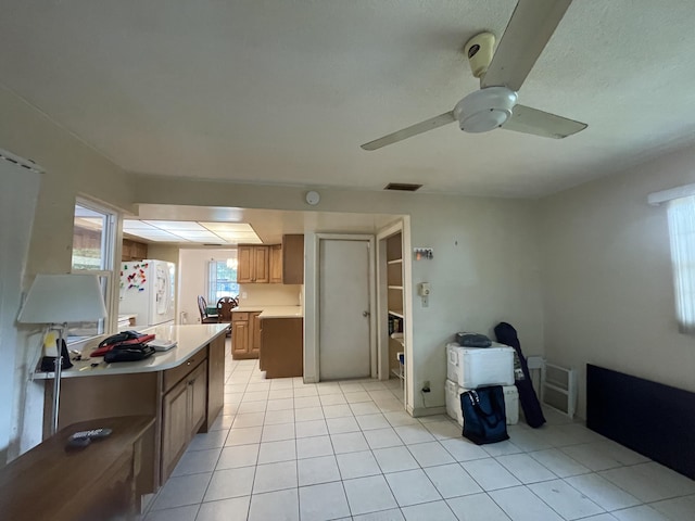 kitchen featuring ceiling fan, light tile patterned floors, and white fridge