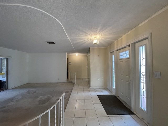 foyer featuring a textured ceiling and light tile patterned floors