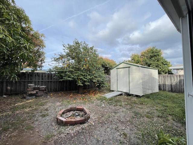 view of yard with a storage unit and a fire pit