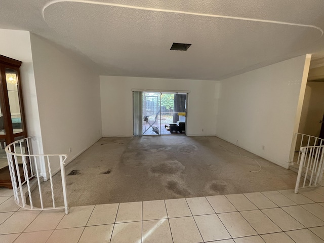 interior space with a textured ceiling and light carpet