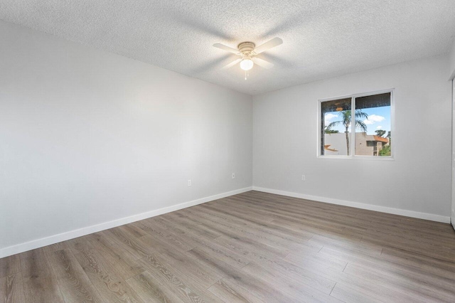 spare room featuring a textured ceiling, light hardwood / wood-style floors, and ceiling fan