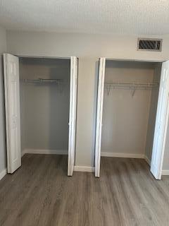 unfurnished bedroom with dark hardwood / wood-style floors and a textured ceiling