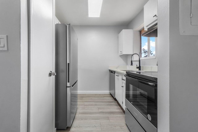 kitchen featuring sink, light hardwood / wood-style flooring, white cabinets, and appliances with stainless steel finishes