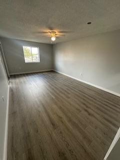 empty room featuring a textured ceiling, ceiling fan, and dark hardwood / wood-style flooring