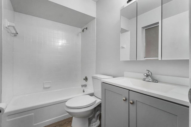 full bathroom featuring hardwood / wood-style flooring, tiled shower / bath, vanity, and toilet