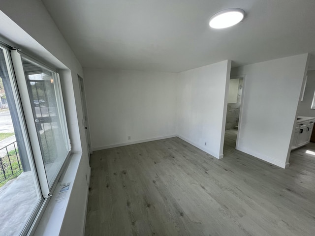 spare room featuring a wealth of natural light and light hardwood / wood-style floors