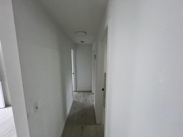 hallway with light hardwood / wood-style floors