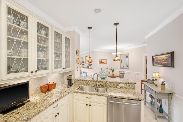 kitchen featuring pendant lighting, sink, stainless steel dishwasher, light stone countertops, and cream cabinetry