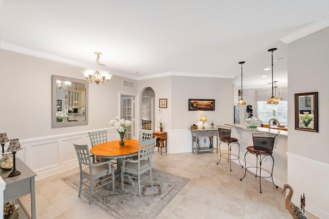 dining area featuring crown molding, an inviting chandelier, and sink