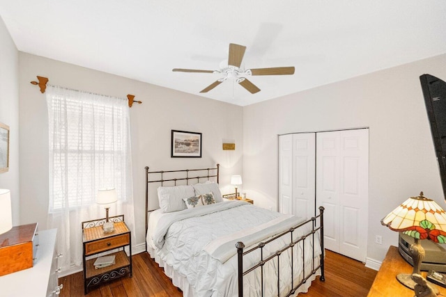 bedroom with dark hardwood / wood-style flooring, ceiling fan, and a closet