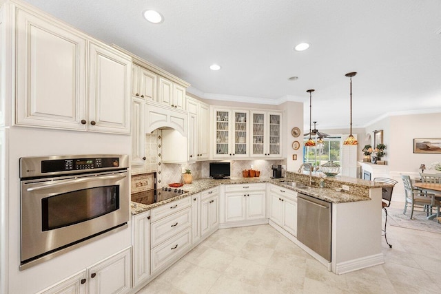 kitchen featuring light stone counters, sink, kitchen peninsula, and stainless steel appliances