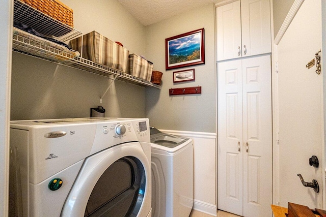 laundry room with washing machine and dryer and a textured ceiling