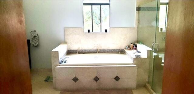 bathroom with independent shower and bath and tile patterned flooring