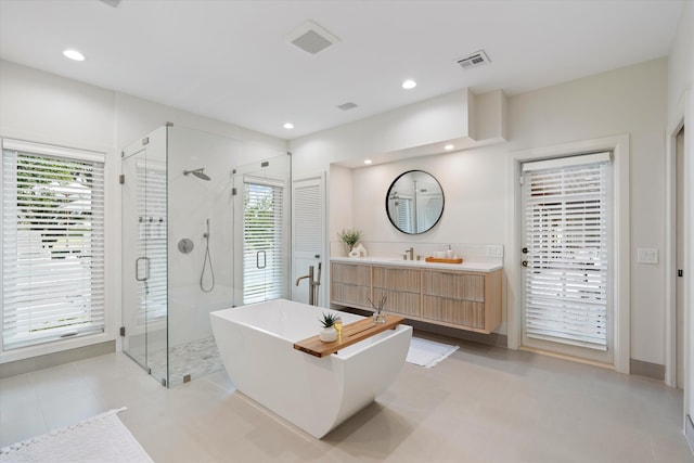 full bathroom with a shower stall, vanity, a freestanding bath, and recessed lighting