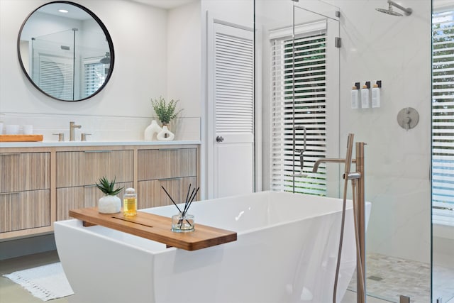 bathroom with a closet, a marble finish shower, a freestanding bath, and vanity