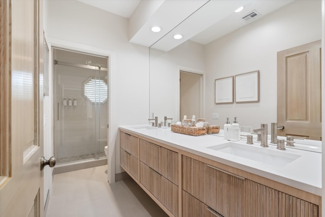 bathroom with toilet, a sink, visible vents, double vanity, and a stall shower