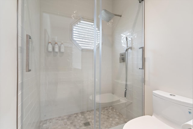 bathroom featuring a shower stall and toilet