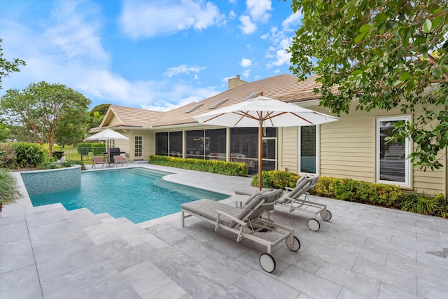 pool with a patio area and fence