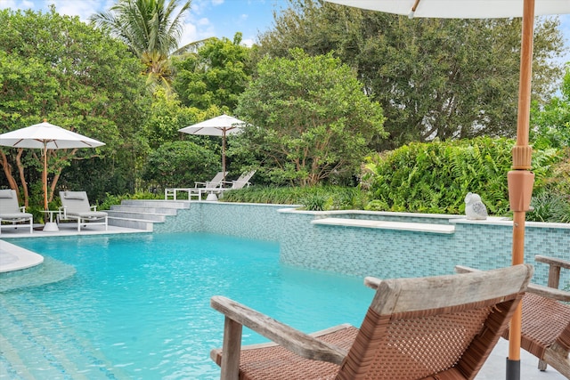 pool with a patio and a hot tub