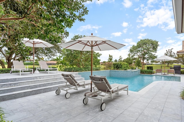 pool with a jacuzzi, fence, grilling area, and a patio