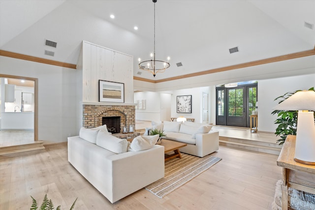 living area featuring high vaulted ceiling, visible vents, light wood-style floors, and a fireplace