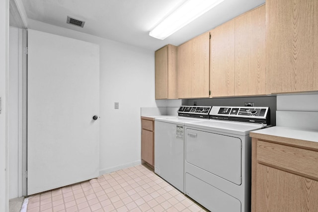 washroom with cabinets and washing machine and dryer