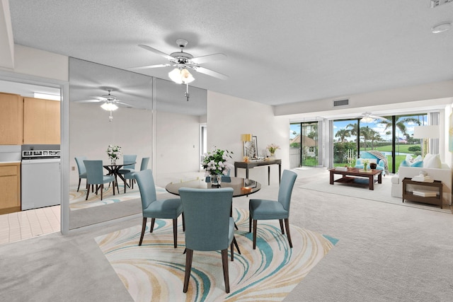 dining space featuring ceiling fan, light carpet, and a textured ceiling