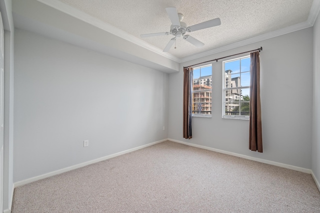 empty room with a textured ceiling, ceiling fan, carpet, and crown molding