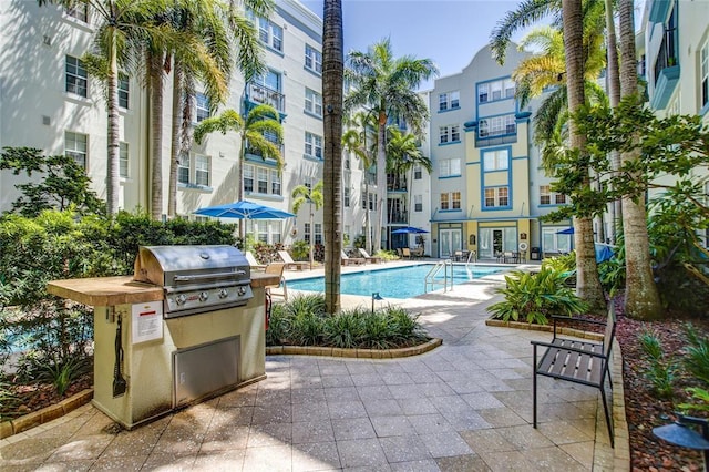 view of pool with an outdoor kitchen, area for grilling, and a patio