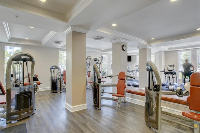 exercise area with hardwood / wood-style floors, ornamental molding, a wealth of natural light, and ornate columns