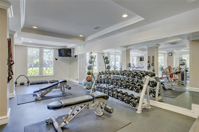 workout area featuring ornate columns, ornamental molding, and a raised ceiling