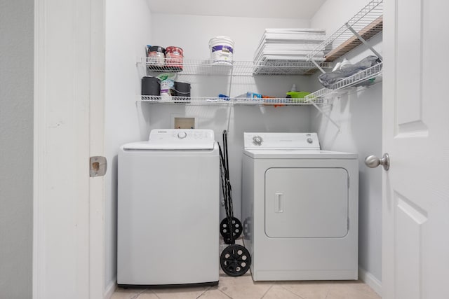 clothes washing area with light tile patterned floors and independent washer and dryer