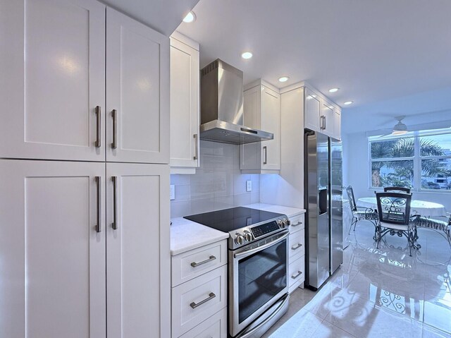 kitchen featuring electric stove, white cabinets, light stone countertops, and beverage cooler