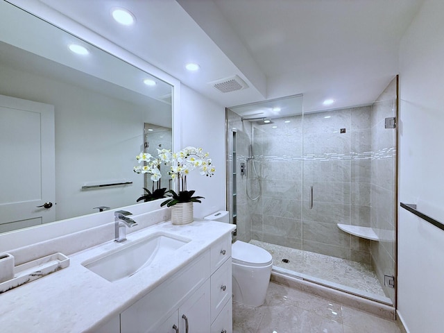 bathroom with toilet, vanity, and a shower with door