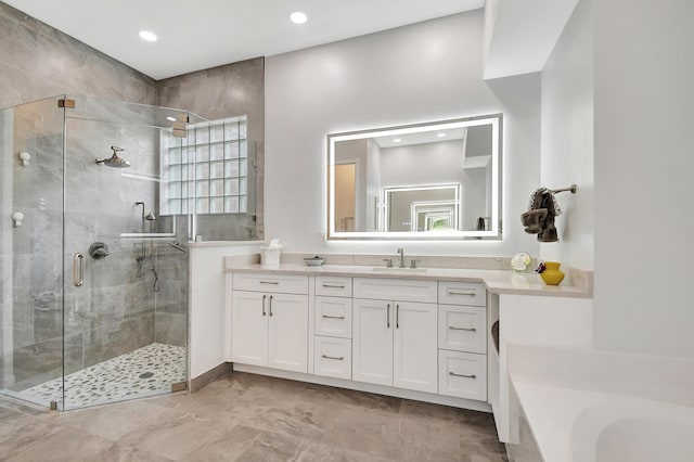 bathroom featuring a stall shower, a garden tub, vanity, and recessed lighting