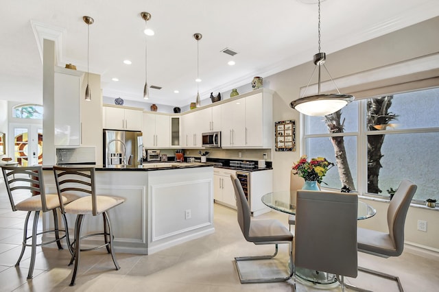 kitchen with hanging light fixtures, stainless steel appliances, and white cabinets