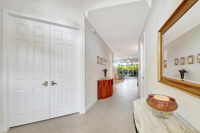 hall featuring light tile patterned flooring and ornamental molding