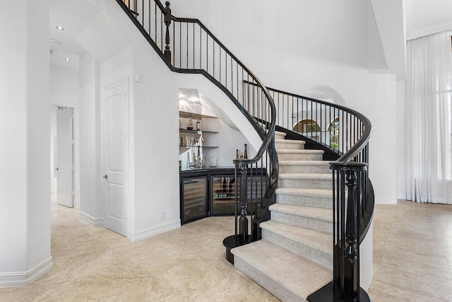 stairway with bar and a towering ceiling