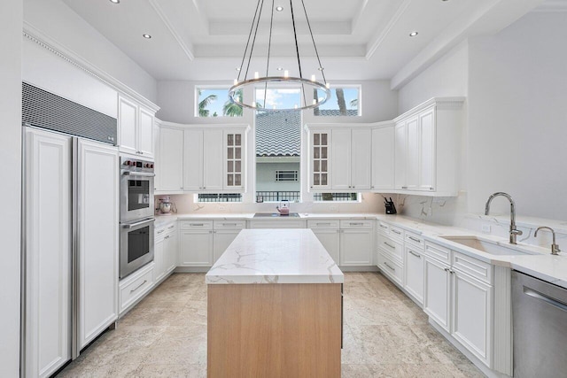 kitchen featuring appliances with stainless steel finishes, sink, white cabinetry, and a center island