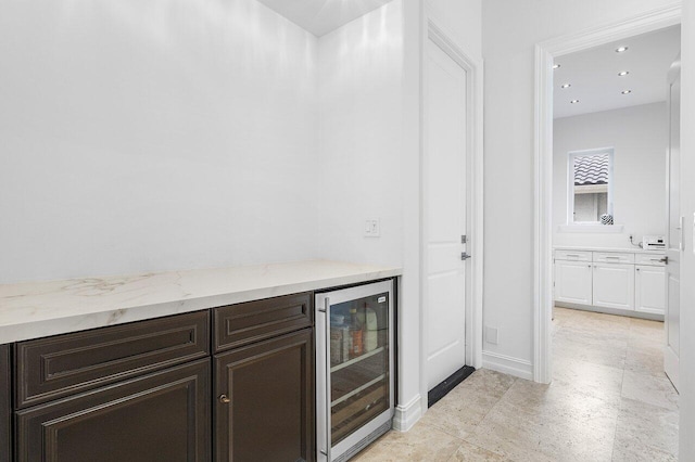 bar with dark brown cabinets and wine cooler