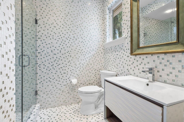 bathroom featuring toilet, vanity, tile walls, tile patterned floors, and an enclosed shower