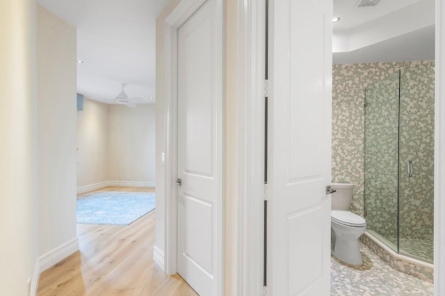 bathroom with ceiling fan, wood-type flooring, toilet, and walk in shower