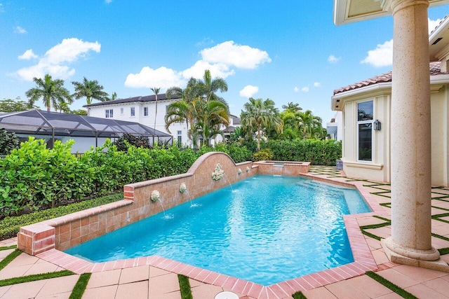 view of pool featuring an in ground hot tub, a lanai, and pool water feature